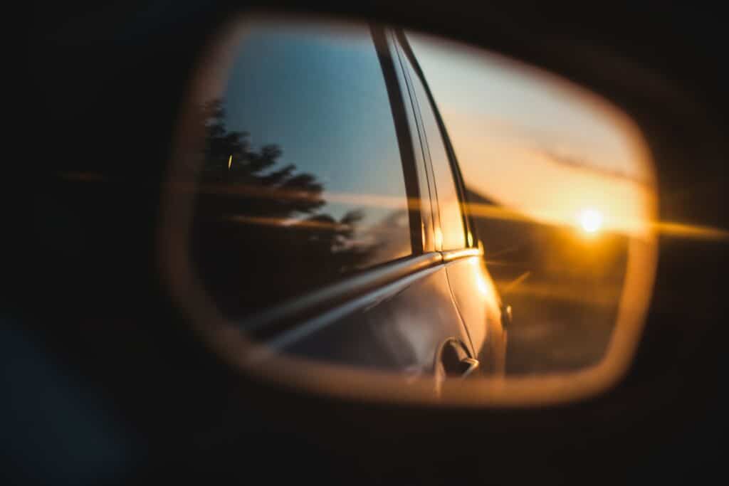 sunset in the side mirror of a car